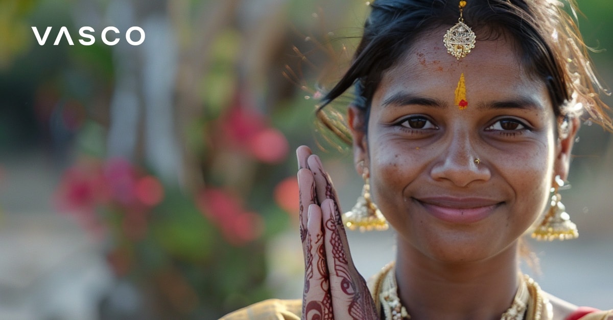 A woman in traditional Indian attire with hands in a greeting gesture, depicting how to say hello in multiple languages.