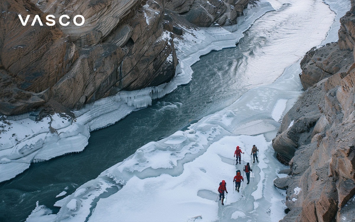 Group of hikers walking on a frozen river through a snowy canyon