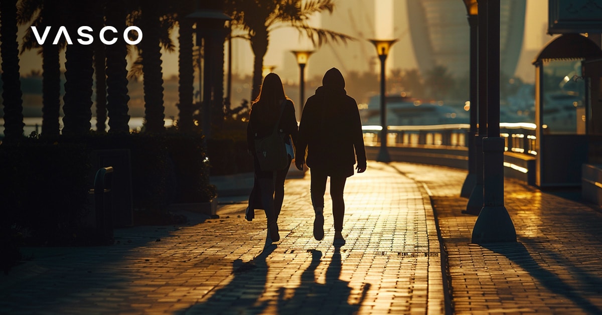 Pár kráčajúci pozdĺž promenády v Dubai Marina pri západe slnka