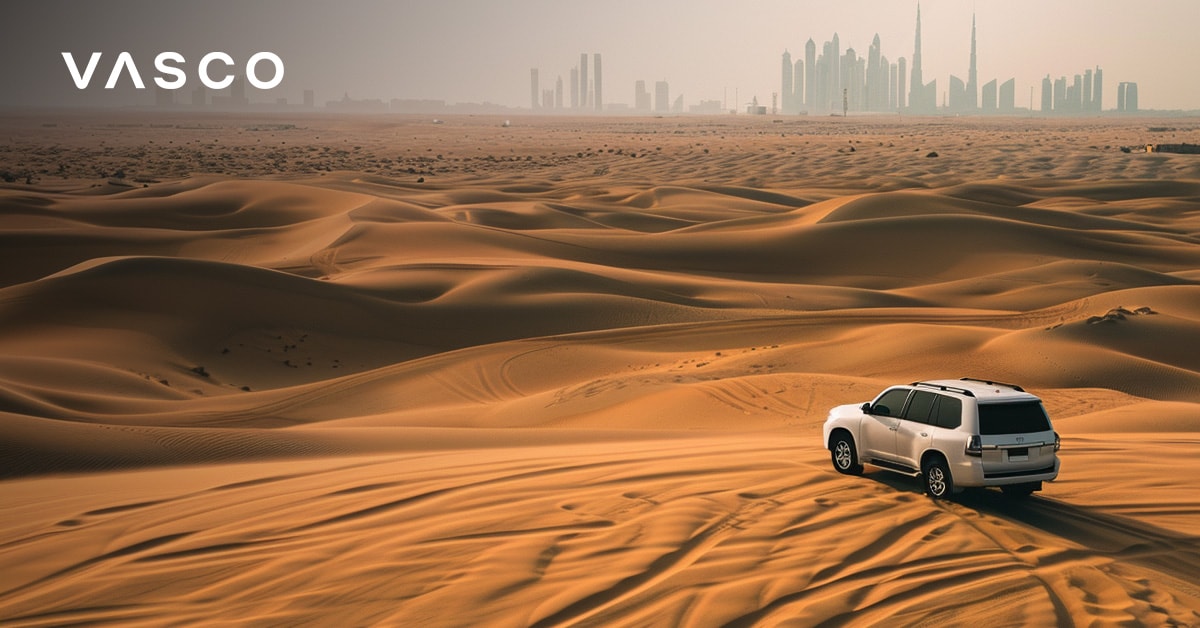 Najlepší čas na návštevu Dubaja: SUV prechádzajúce cez dubajskú púšť s panorámou mesta v diaľke