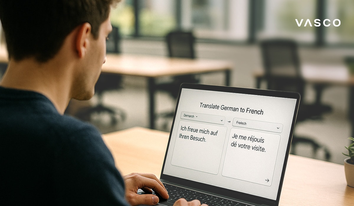 Muž používa notebook na preklad vety z nemčiny do francúzštiny v modernom pracovnom priestore.