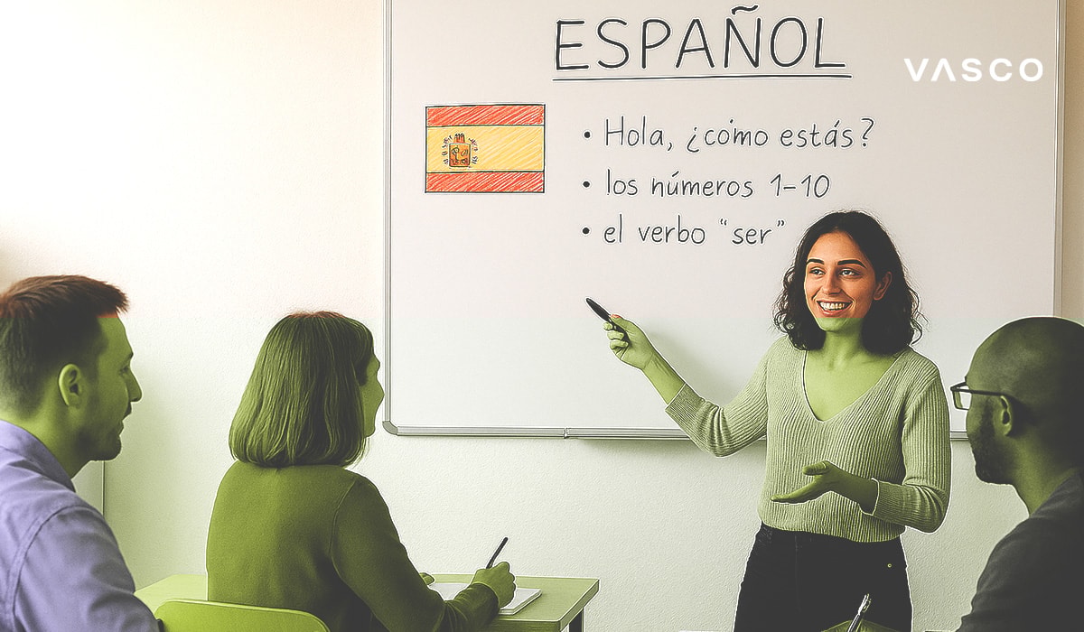 Young woman teaching a Spanish language class, pointing at a whiteboard with basic Spanish phrases written next to a hand-drawn Spanish flag.