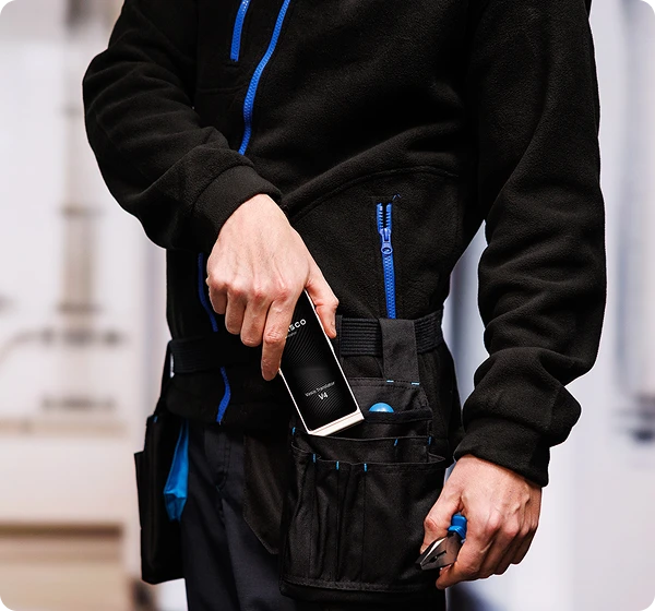 Muž v pracovnom oblečení vyťahuje Vasco Translator V4 z opasku na náradie.