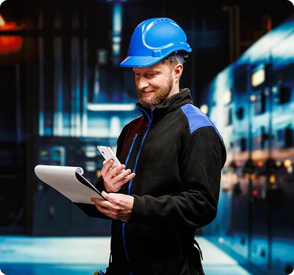 Dvaja muži spolu komunikujú; vodič kamióna drží Vasco Translator V4 a pracovník skladu oproti nemu má v rukách dokumenty. Komunikujú pomocou zariadenia Vasco.