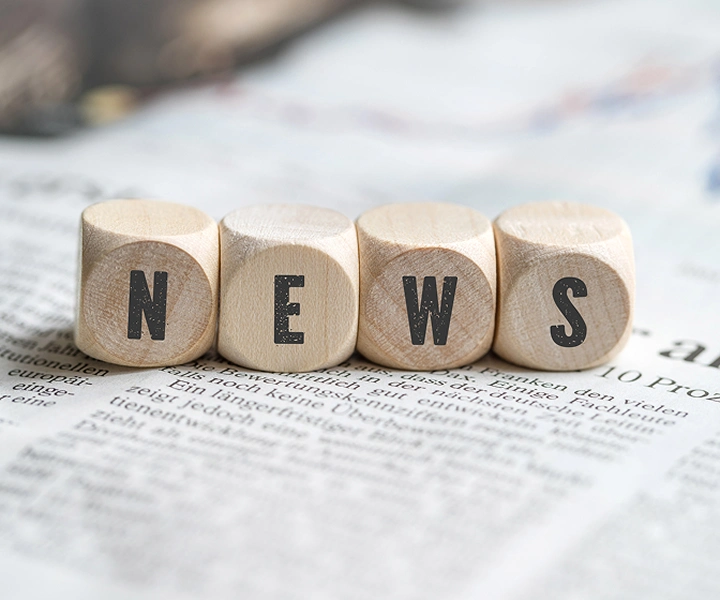 Kocky s nápisom „NEWS“ ležiace na novinách.